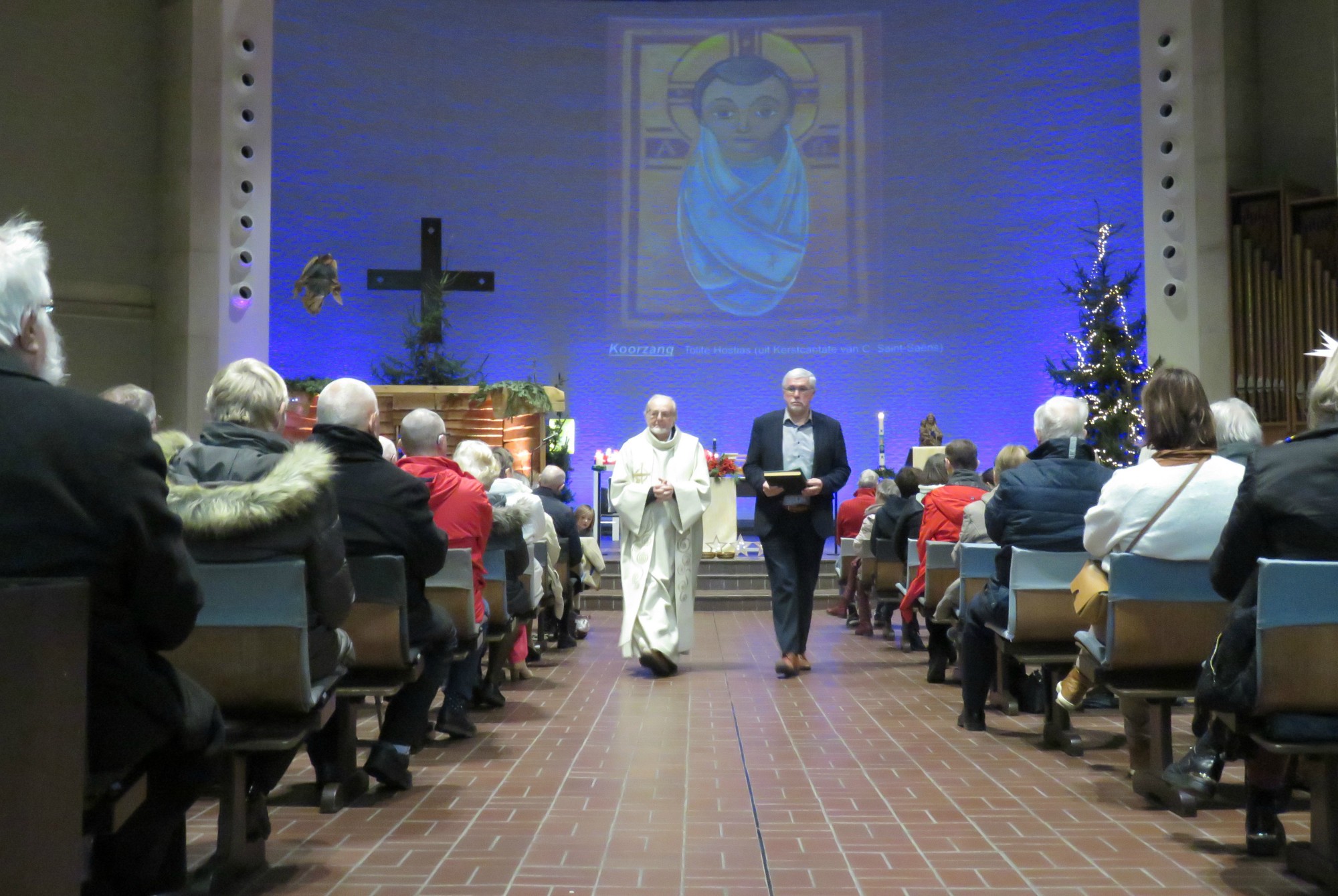 Priester Paul Scheelen en lector Jan Van Noten begroeten de vele aanwezigen